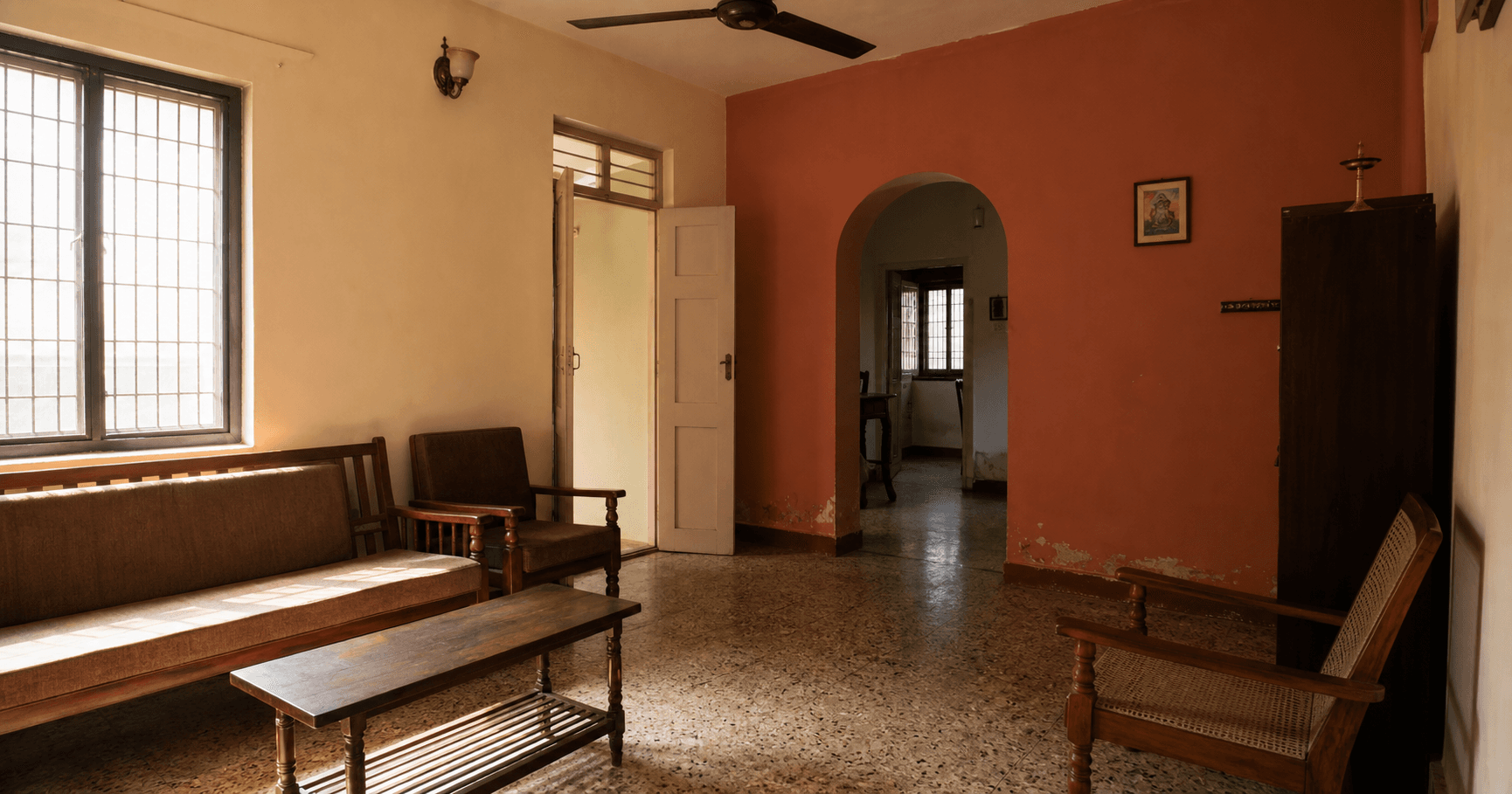 South Indian living room with matt ivory and terracotta walls, a grille window and ceiling fan